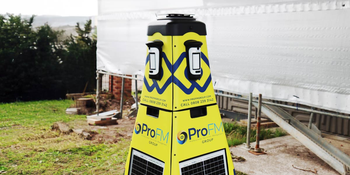 A yellow ProFM mobile security tower with built-in solar panels deployed next to a construction site structure