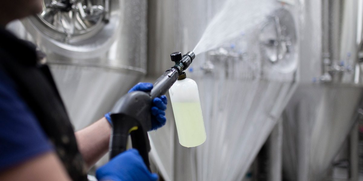 Industrial cleaner sanitising production equipment and machinery as part of a factory deep cleaning programme.